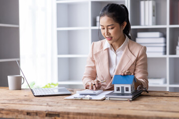 Business woman Real estate broker agent working with home model document presenting and sign insurance form agreement consult concerning mortgage loan offer in office.