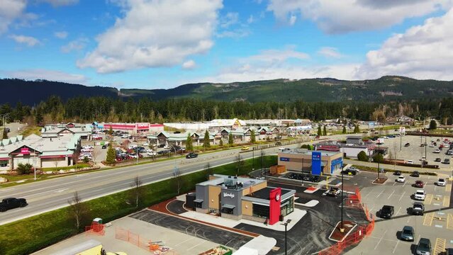 Cars Driving In The Road Passing By Fast Food Restaurant Chain In Port Alberni, BC, Canada. - aerial