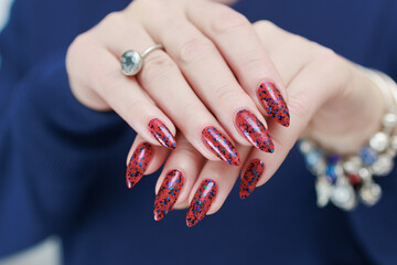 Female hand with long nails and a bright red manicure