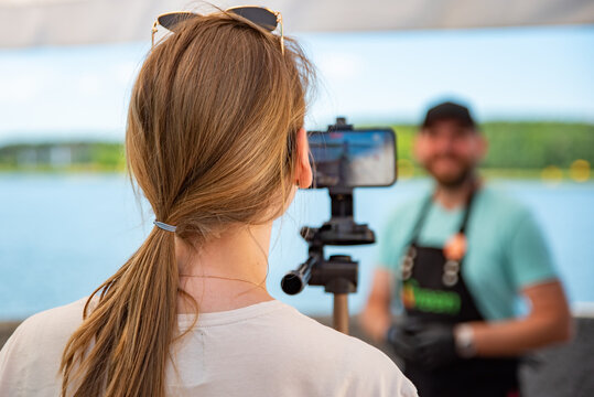 man chef gives an interview for a video blogger. videographer is filming the cook's story about cooking. outdoor
