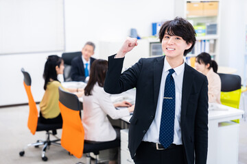 笑顔でガッツポーズをする若いビジネスマン