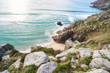 Porthcurno, Cornwall, UK - Top view of Pedn Vounder Beach with rocks and ocean on a sunny day