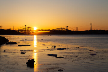 The 1970 Pierre-Laporte and the 1904 Quebec bridges over the St. Lawrence river in silhouette...