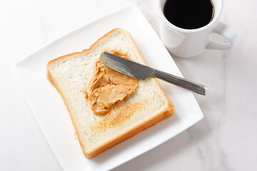 ピーナツバターを塗った食パンとコーヒーの朝ごはん