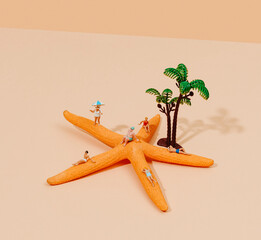 miniature people in swimsuit on a starfish