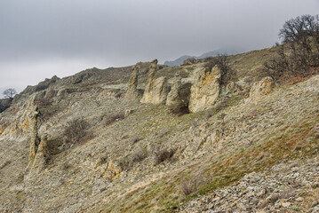Fototapeta premium Gingerbread horse rock and bizarre rocks in Dead city. Khoba-Tele Ridge of Karadag Reserve in spring. Crimea