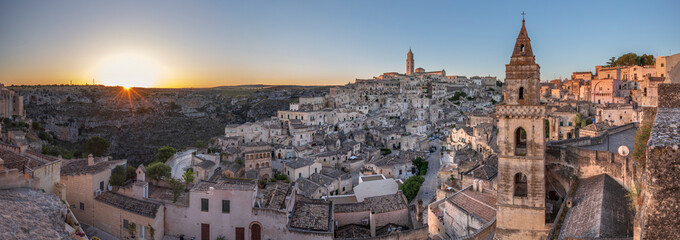 Sun rising over the canyon and Sassi di Matera old town with the campanile of the church of Saint Peter Barisano, UNESCO World Heritage Site, Matera, Basilicata