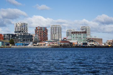 Obraz premium Panoramic view from the IJ river to NDSM neighborhood (Amsterdam-Noord borough), located on the former terrain NDSM-wharf, along the IJ river. AMSTERDAM, The NETHERLANDS.