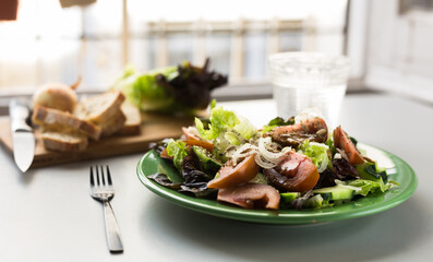 vegetable salad of greens, tomatoes and cucumbers on a green plate