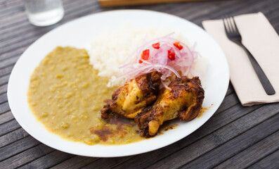 chicken wings with mashed peas, rice and pickled onions on white plate