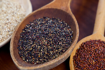 black quinoa close-up in wooden spoon, selective focus