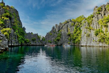 Fototapeta na wymiar A bay with majestic rocks in Coron, Palawan in the Philippines that are overgrown with shrubs and rise out of the water.
