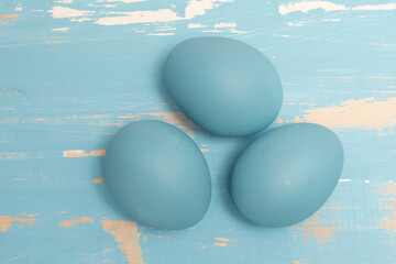 Eggs symbolizing the Easter holiday in blue color on a background of aged wood