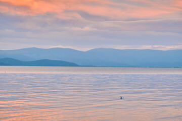 Chivyrkuysky Bay of Lake Baikal in the Buryat Republic in the evening during sunset.