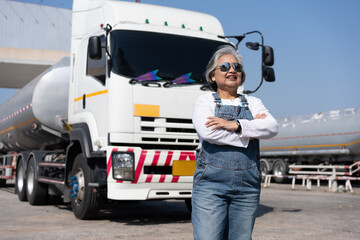 Business owner standing in front of oil truck after performing a pre-trip inspection on a truck....