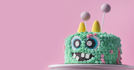 Monster theme cake on the pink background. Funny birthday cake with turquoise fluffy cream cheese...
