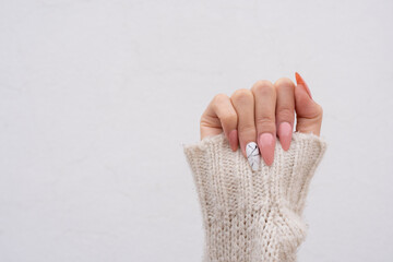 showing pink sculpted fingernails by raising the arm 