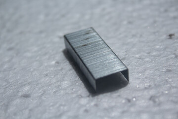 portion of metal staples on a white background