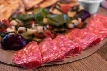 Sausage slicing and vegetables in the restaurant. Close-up. Gluttony, unhealthy diet, dependence on food.