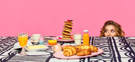 Banner of one adorable red headed girl sitting under table and looking on food over pink...