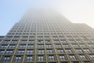 An apartmentbuilding in The Hague with the upper part of the building in the fog.