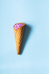 Wafer cone with tulips on a blue background. Flower ice cream, spring concept with first flowers.