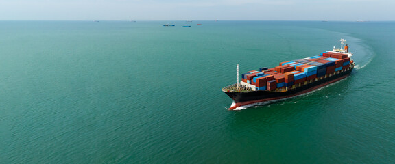 Container ship carrying container import and export, business logistic transportation by container ship in sea,  panoramic copy space for graphic design banner web and tex, aerial view. © SHUTTER DIN
