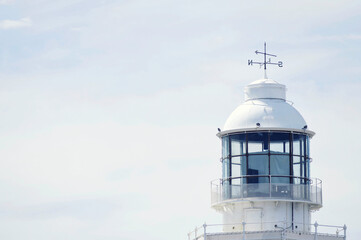 Fototapeta na wymiar White lighthouse and bright sky