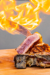 Coltello da carne infuocato mentre infilza un pezzo di bistecca cotta al sangue poggiata su un...
