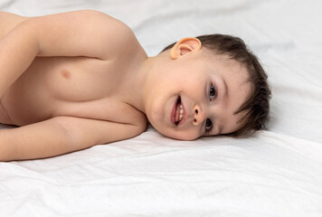 baby boy cuddling on bed with father dad,playing relaxing with silicone pop it toy,holding up one...