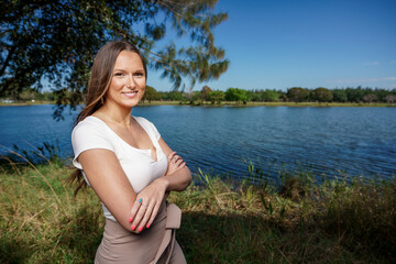 Beautiful young woman posing outdoors with arms crossed