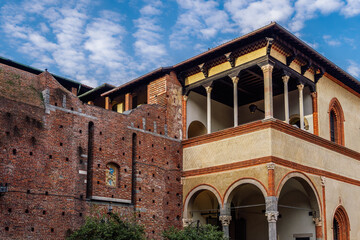 Fototapeta premium Milan, Italy Ducal Courtyard low angle day view of Sforzesco Castle - Castello Sforzesco - Medieval apartments residence, the loggia of Galeazzo Maria Sforza against puffy clouds sky.