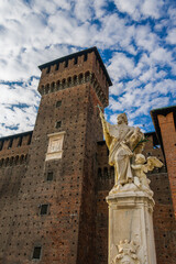 Milan, Italy 1729 statue of Saint John of Nepomuk - San Giovanni Nepomuceno - protector of soldiers, in the main courtyard of Medieval fortress Sforzesco Castle, Castello Sforzesco against sky clouds.