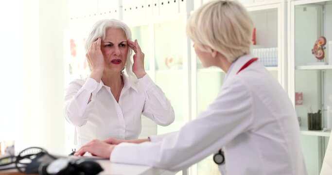 Elderly woman patient complaining of headache and memory loss to neurologist doctor in clinic 4k movie slow motion