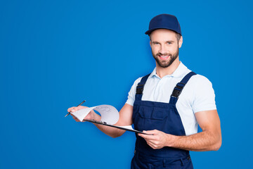 Portrait with copyspace, empty place of positive confident deliver in blue uniform having clipboard with papers in hands looking at camera isolated on grey background