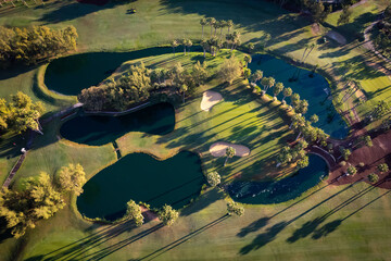 Aerial view above golf course surrounded by villas, condos and resort in Playa las Americas,...