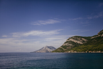 Landscape of the Adriatic Sea, mountains with clouds, sky, rocks on a sunny day. Dalmatia, Croatia.