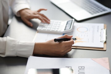Businesswoman working with documents is auditing and analyzing finances for budget planning.