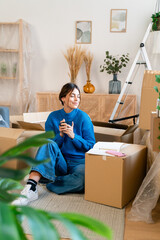 Female in casual clothes sitting during relocation into new apartment