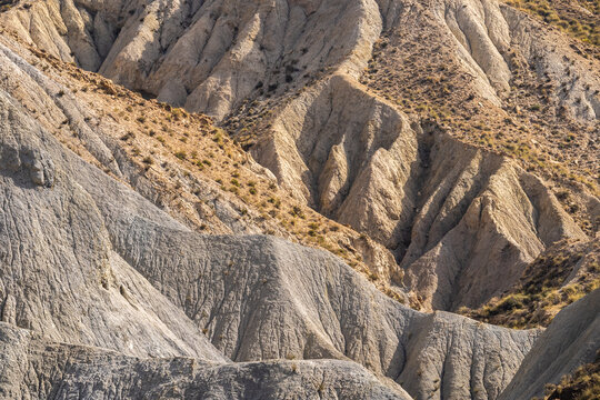 Rocky cliff terrain with dry land in desert