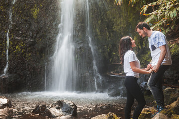 Happy couple standing near waterfall in daylight
