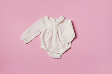Mockup of cream infant bodysuit made of organic cotton with eco friendly baby accessories on pink...