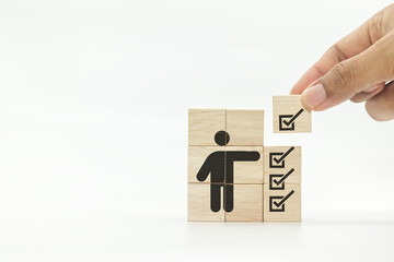 Person and checklist icons on wooden cubes. Symbolizing to checklist survey and assessment process. Quality control management, ISO certification. Product, service quality warranty. 

