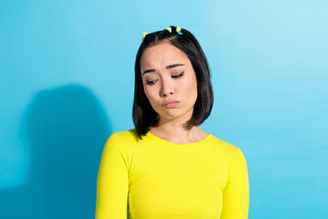Creative photo portrait of youngster korean girl with ponytails hair pouted lips look down feel offended displeased isolated on blue color background - obrazy, fototapety, plakaty