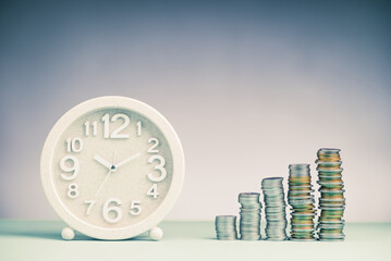 Clock and growth of money heap coins, financial, money and time concept, investment, and saving