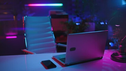 Neon metaverse futuristic concept. modern office with desk, laptop and virtual reality goggles.