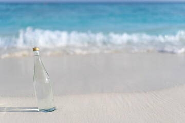 Glass bottle of pure water on the background of ocean