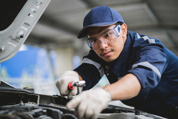 Close-up shot of working in a repair and maintenance service garage. Auto mechanic working on car...