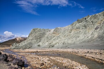 River running through a rocky valley next to a mountain