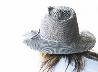 Close-up shot of a woman in a straw hat with a white background